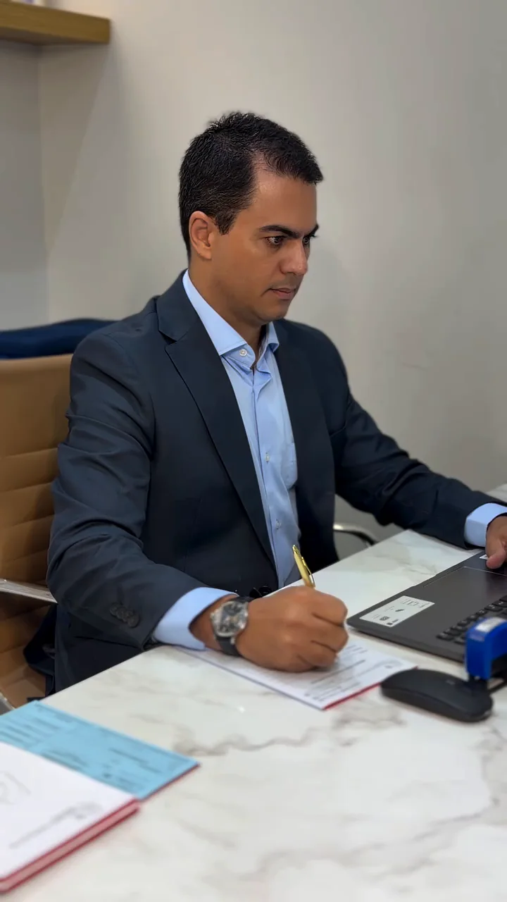 Dr. Deivson Gonçalves escrevendo no consultório