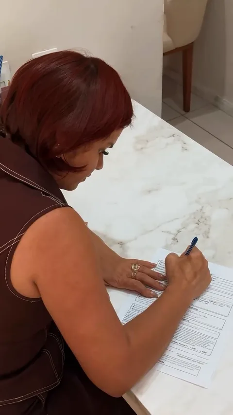 Thaís Gonçalves preenchendo a ficha de atendimento